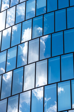 Reflections on a contemporary building facade showing glass windows and urban city architecture exterior