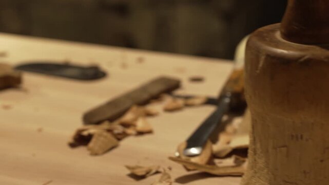 The master crafts traditional wooden string instruments by hand. The traditional musical instrument is the Calabrian lyre. The master works in the cozy light of his workbench.