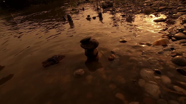 Defocused Sacred River Bathing at Sunrise at Devghat Dham, Nepal, with Balanced River Stones in Foreground, Hindu Pilgrimage, Spiritual Ritual, Golden Morning Light and Riverside Culture