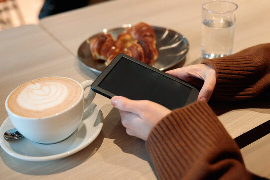 Woman holding e-reader at cafe