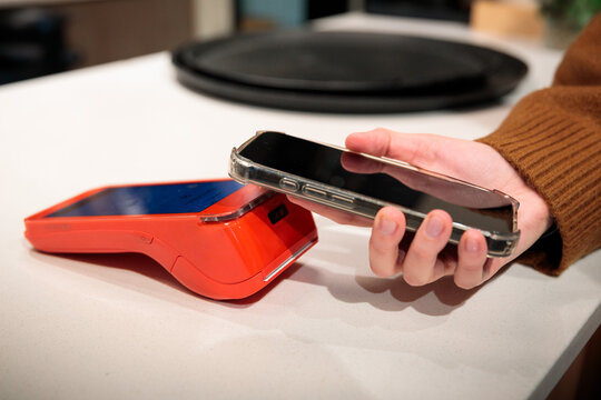 Woman making contactless smartphone payment