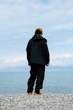 A Traveler's Silhouette Enjoying Serenity on the Vast Lake Shore.