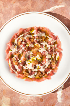 Gourmet raw red tuna tartare with white sauce and fresh herbs