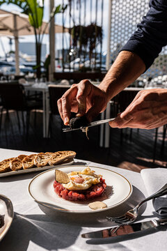Chef hands shaving fresh black truffle over raw tuna tartare 