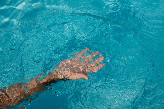Hand Moving Through Swimming Pool Water