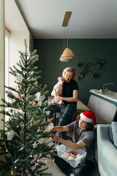 Joyful Family Decorating a Christmas Tree at Home