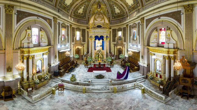 Aerial view of the ornate interior of the Basilica of Our Lady of Health featuring a golden altar, marble floors, and stained glass windows in Patzcuaro, Michoacan, Mexico.
