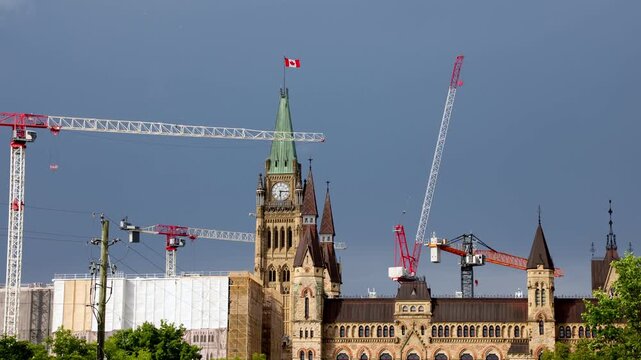 Parliament Hill restoration site with construction cranes in Ottawa. Historic Canadian parliament buildings renovation.