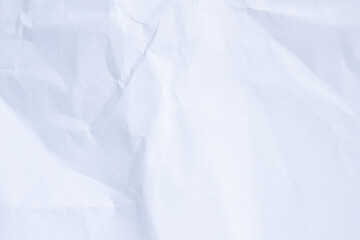 Fototapeta premium White crumpled paper forming a textured background, highlighting its rough surface, creases, and abstract folds