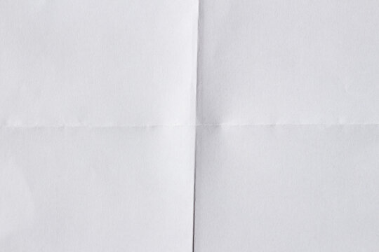 Blank white paper sheet with horizontal and vertical folds creating four empty sections, a clean texture background