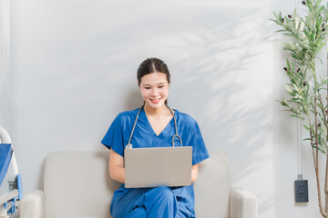 Nurse with Laptop: A young female nurse in blue scrubs, wearing a stethoscope around her neck,...