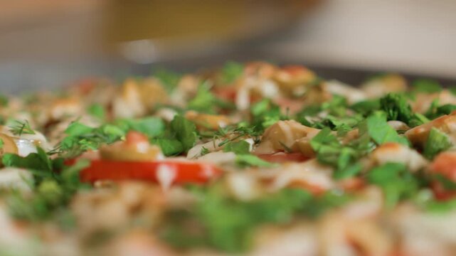 Low-angle close-up across freshly baked pizza on pan showing melted, stringy cheese stretching over sliced tomato, mushrooms, and chopped green herbs; glossy sheen and slight steam indicate residual