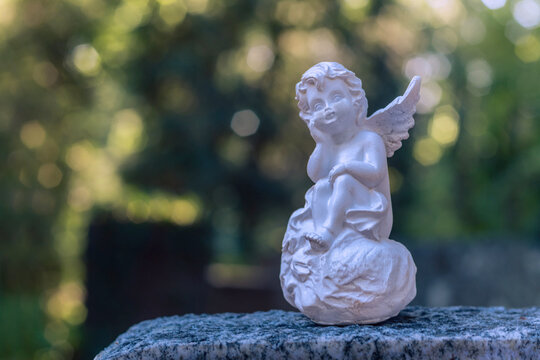 Details bei Gegenlicht im Park Friedhof im August mit Engelsfiguren 