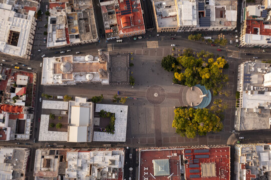 Aerial view of the historic Plaza de la Patria in downtown Aguascalientes, featuring the cathedral, lush trees, and colonial architecture in Aguascalientes, Aguascalientes, Mexico.