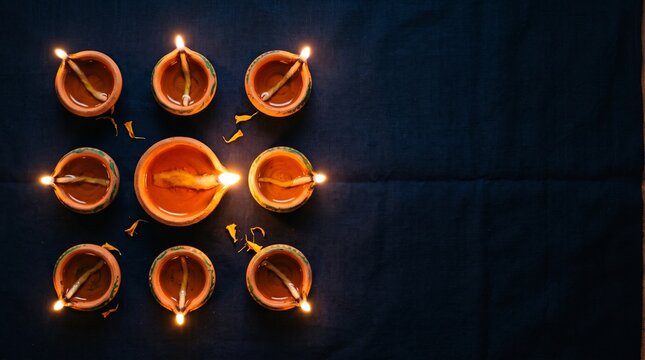 Top view of traditional clay oil lamps glowing in a square pattern for the hindu festival of diwali