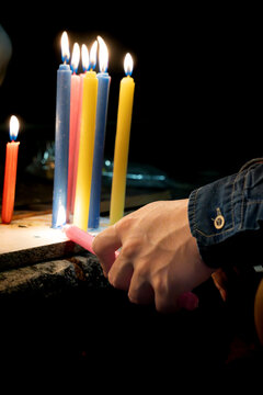 Hand Lighting Blue Candle with Pink Candle at Night. Candle Day, Colombia
