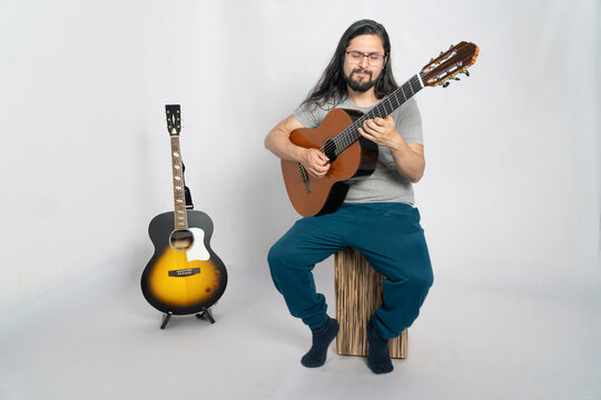 Musician Passionately Playing Classical Guitar on Cajon in Studio