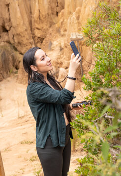 Woman Taking Photo with Smartphone outdoors in Clay Valley. Tatacoita - Nemocon