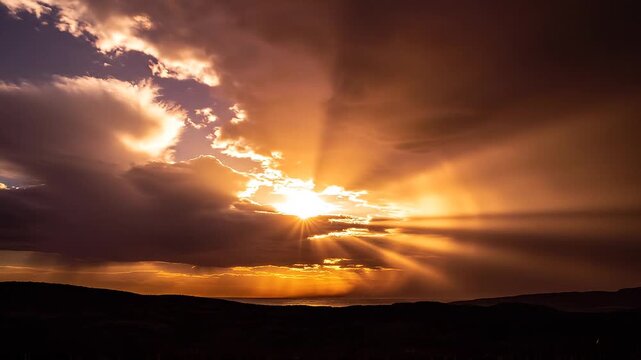 Impresionantes rayos de sol dorados atravesando densas nubes de tormenta durante un atardecer &eacute;pico.