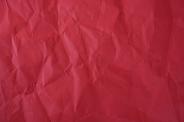 Fototapeta premium Crumpled red paper texture background with deep wrinkles, folds, and subtle shadows