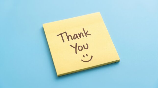 Simple yellow sticky note with handwritten thank you message and a smiling face