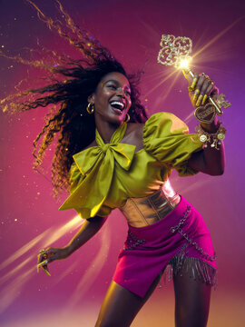 A dynamic and energetic portrait of a stylish fashion woman in a vibrant, motion-filled pose, holding an ornate golden key that symbolizes the key to happiness, with flowing hair and dramatic lighting