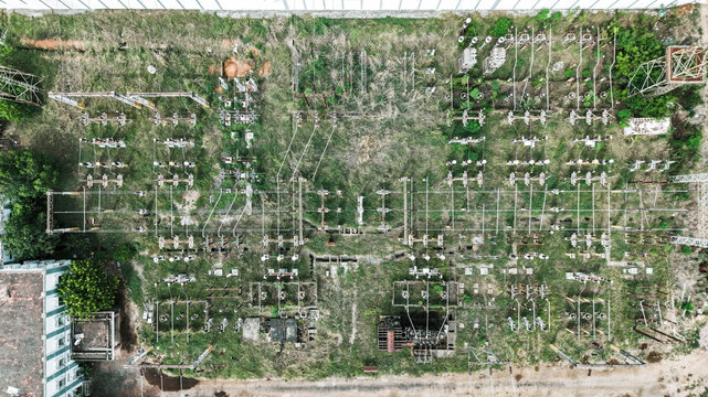 Aerial view of the electrical substation in Tharamani, featuring transformers, power lines, and metal structures amidst overgrown vegetation in Chennai, Tamil Nadu, India.