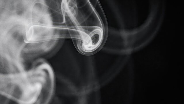 Abstract white smoke swirls against solid black background for artistic graphic design projects.