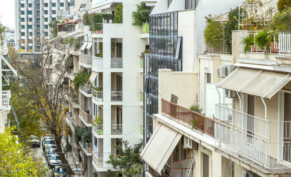 Dense urban apartment balconies overlook a tree-lined street in Kolonaki, Athens, Greece