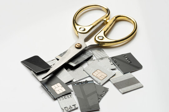 Cutting up old sim cards with scissors on a white surface