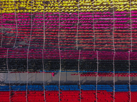 Aerial view of colorful fabrics hanging on lines to dry in a textile dyeing area in Narayanganj, Dhaka, Bangladesh.