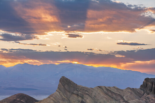 Beautiful wide view of sunrise sunbeams over Manly Beacon and Panamint mountains in Death Valley