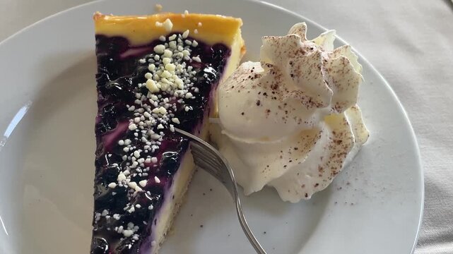 Ein St&uuml;ck Obstkuchen mit Sahne auf einem Teller.