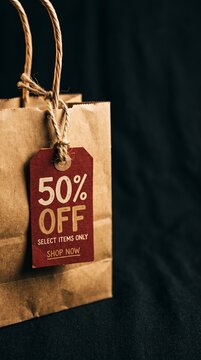 Brown paper shopping bag with red discount tag offering fifty percent off on select items
