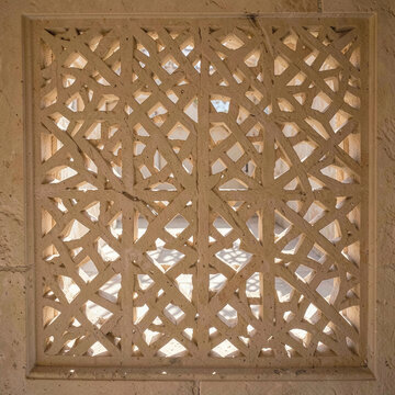 Pierced sandstone jali screen casting geometric shadow