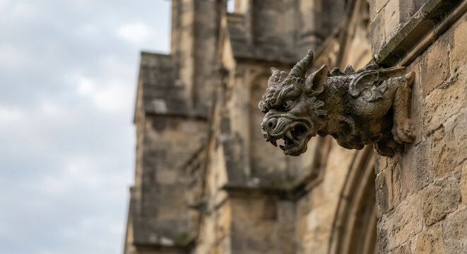 Close-up of a stone gargoyle sculpture on a gothic architecture building.