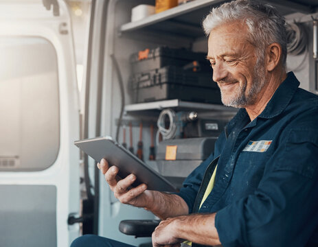 Electrician Using Scheduling App on Tablet in Service Van