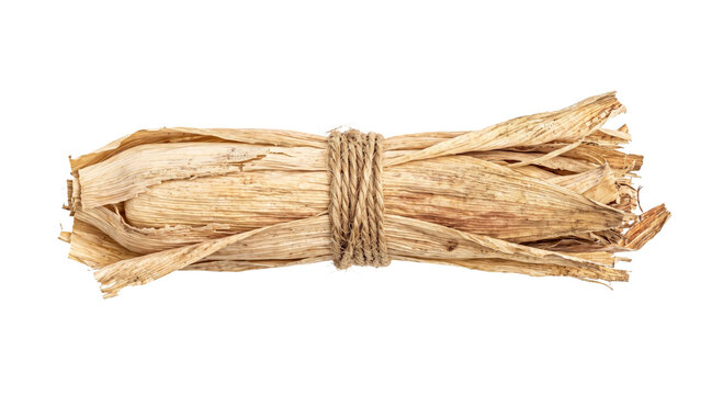 Bundle of dried corn husks tied with rough twine on a white background