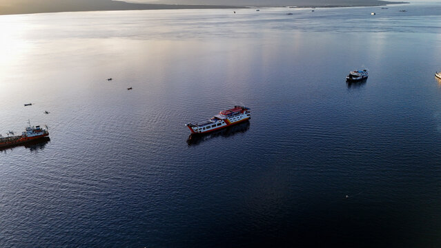 Aerial view of Ketapang Ferry Port with ferries navigating the calm waters of the Bali Strait in Banyuwangi, East Java, Indonesia.