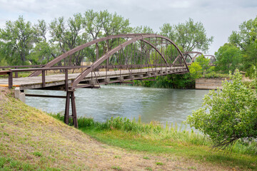Fototapeta premium The historic 1875 Fort Laramie Bridge, also known as the Army Iron Bridge, in southeastern Wyoming is a rare three-span wrought-iron truss bridge spanning the North Platte River.