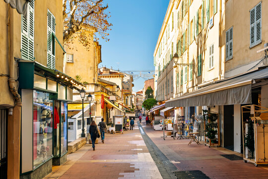 Winter view of Rue Saint-Michel, a historic pedestrian shopping street in the central old town of Menton, France, along the French Riviera.