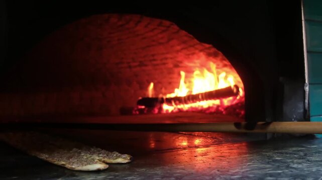 Meat flatbread baking inside traditional stone oven