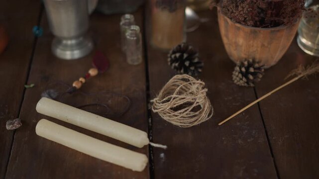 Wooden objects arrangement and placement of wooden items on, in a wooden table with various decorative items, with wooden sticks, twine, pine cones, small bottles, with brown, white accents.