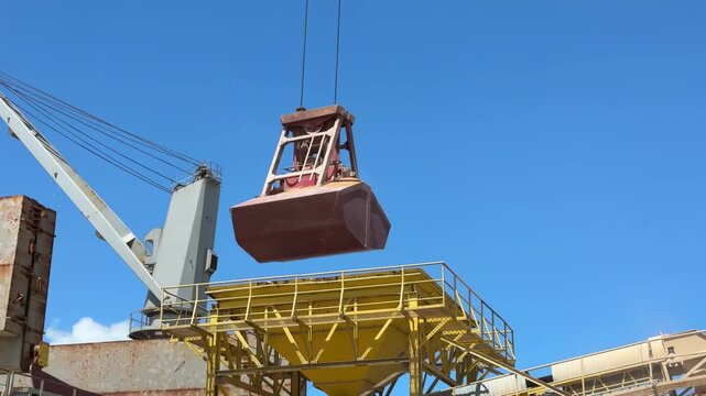 crane grab put grane to the hopper in port.