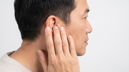 Fototapeta premium Asian man touching ear with hand, male patient suffering from earache or hearing loss, medical concept of tinnitus and ear infection