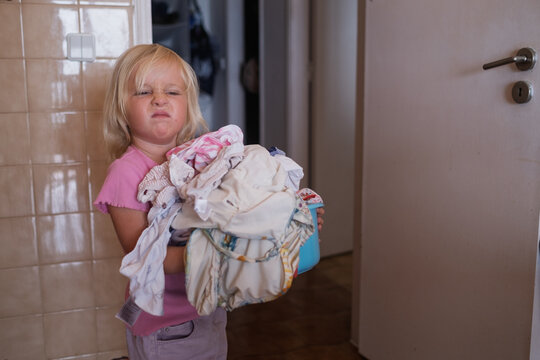  Girl Carrying a Basket of Laundry Near the Washing Machine
