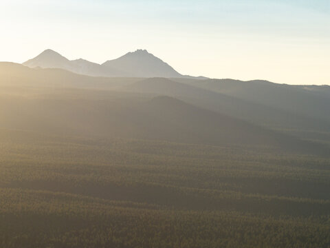 Evening sunlight falls on the Deschutes National Forest near Bend, Oregon. This scenic region in central Oregon is known for its rugged mountains, extensive forests, and flowing rivers.