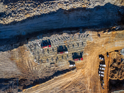 Aerial view of Holcim Australia - Petrie Quarry showing drilling patterns, heavy machinery, and parked trucks in Kurwongbah, Queensland, Australia.