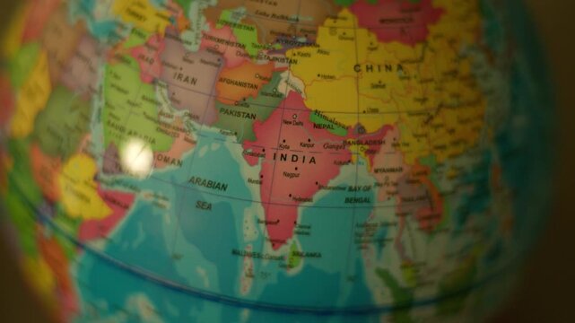 Colorful globe rotates, spotlighting Asia's diverse nations. Close-up view highlights India, China, Iran, and Arabian Sea. Smooth motion conveys global geography and cultural diversity