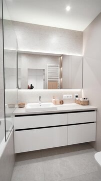 white bright bathroom in a modern renovated one-room apartment. elite hotel room. interior design, new renovation. mirror with backlight, light colors